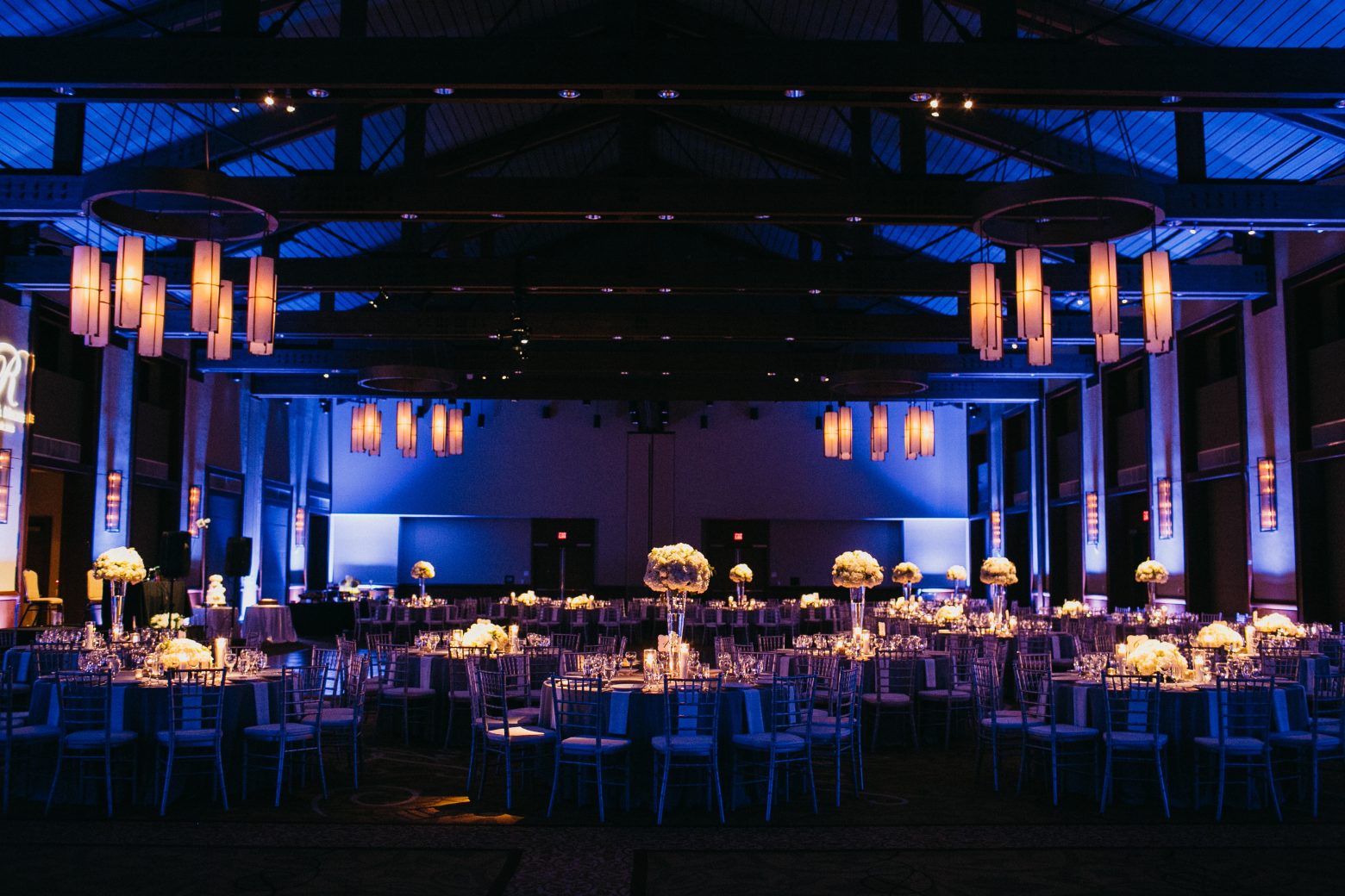a large event space with tables, chairs, and flowers