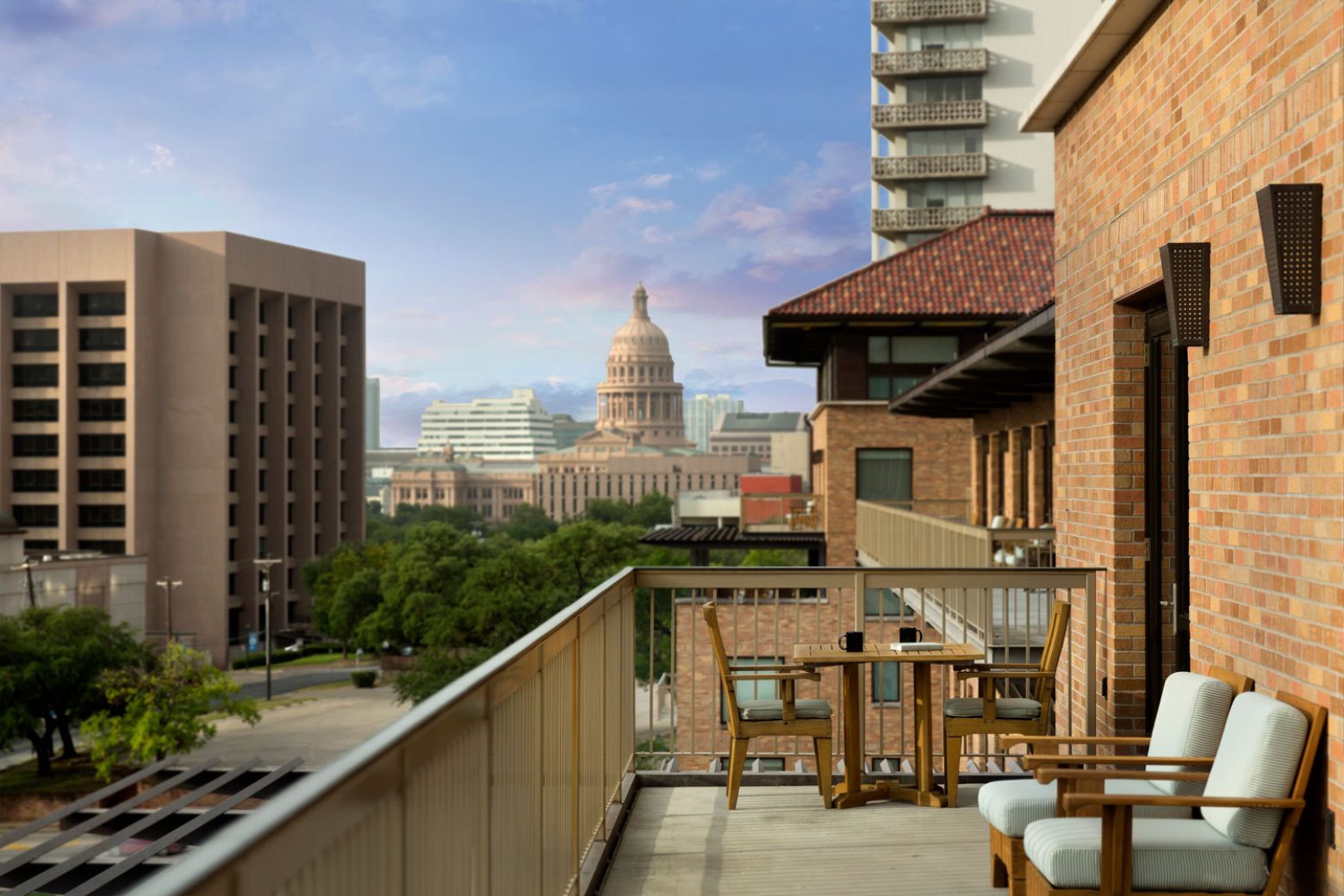 A balcony with seating and a view of the city, including the capitol building.